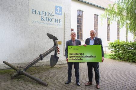 Bild von Sascha Grajewski (Montag Stiftung) und Dekan Ralph Hartmann vor der Hafenkirche