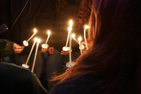 Mehrere Menschen halten Kerzen in der Hand